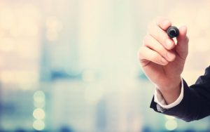 Businessman drawing something with a black maker on blurred abstract background