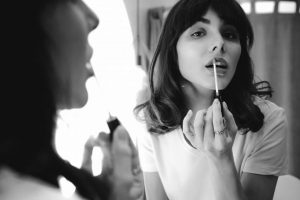 woman applying lipstick - black and white
