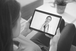 Woman on iPad talking to doctor - black and white