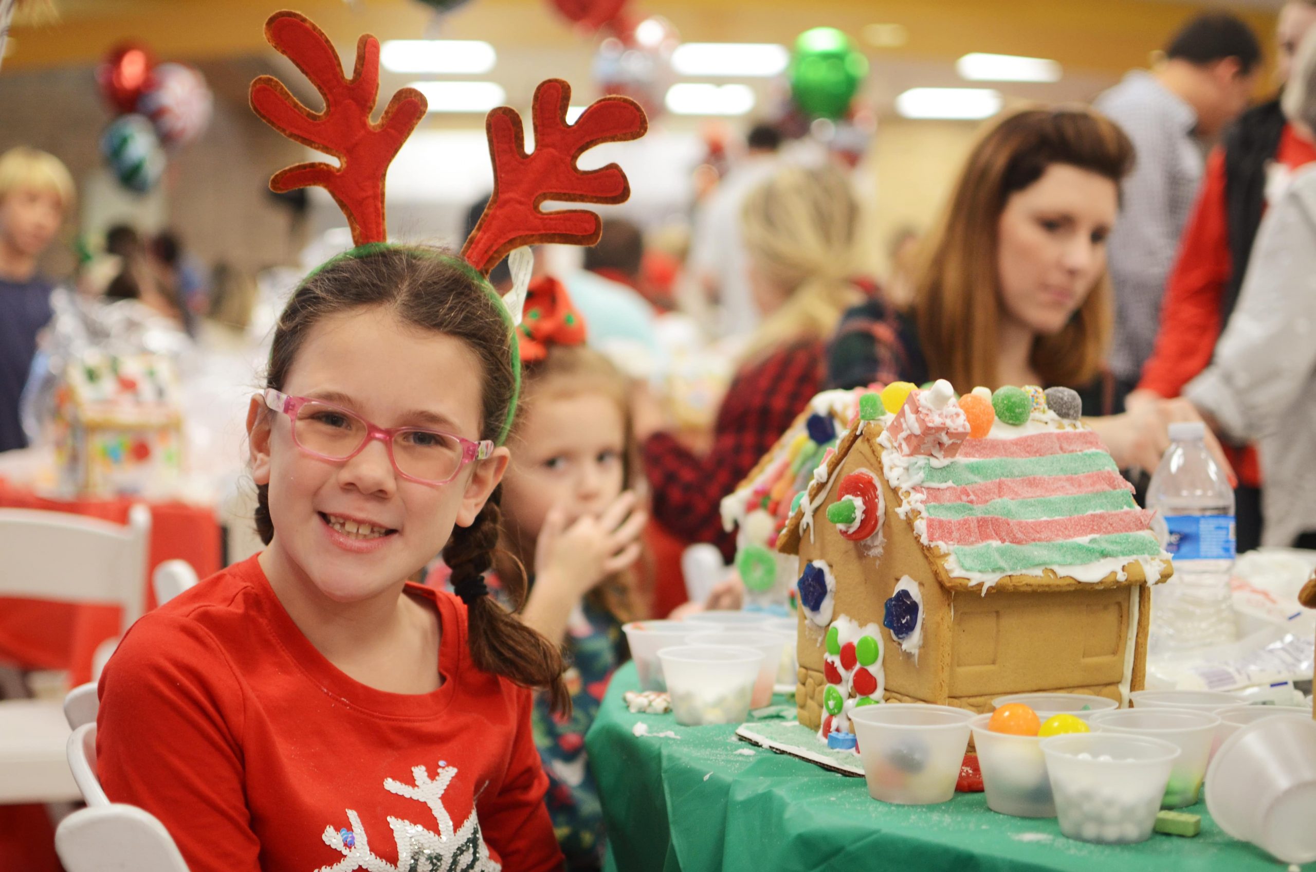 child decorating gingerbread house Cookies & Castles event