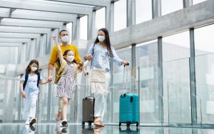 family traveling in airport masks and travel post-covid coronavirus