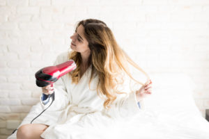 Cute,Woman,In,A,Bathrobe,Sitting,On,Her,Bed,And